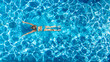 © Iuliia Sokolovska - Active girl in swimming pool aerial drone view from above, young woman swims in blue water, tropical vacation, holiday on resort concept
