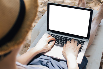 Close-up of young male business freelancer / digital nomad working on laptop with white screen - ready to insert any graphics