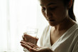 © PORNCHAI SODA - depressed women hand hold medicine with a glass of water, healthcare and medicine recovery concept