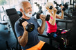 © NDABCREATIVITY - Senior fit man and woman doing exercises in gym to stay healthy