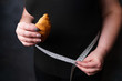 diet, sugar addiction, nutrition choices, conscious eating, overeating. overweight woman with sweet fattening croissant and measure tape. weight loss