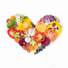 Wall Mural - Heart shaped sliced vegan food pile on white background.