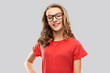 education, school and people concept - smiling teenage student girl in glasses and red t-shirt over grey background