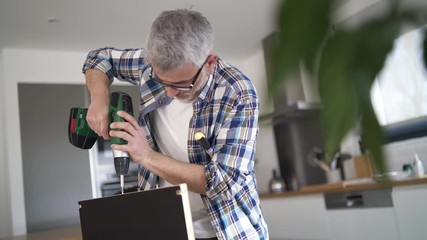 Wall Mural - Man drilling holes in plank in modern kitchen