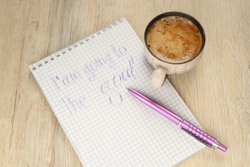 mug with coffee and a pen on a notebook with the inscription i'm going to the goal