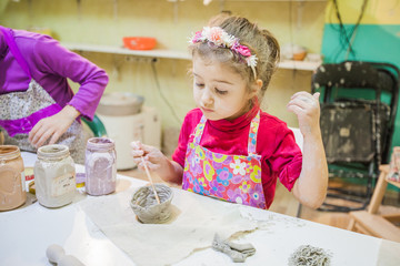 Wall Mural - Little Girl At Pottery Workshop Painting Clay Vase