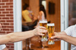 © izikmd - Cropped image Hands of a group of voiced glasses of beer, parties and celebrations. beer glasses at home on the terrace of the house