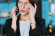 © golubovy - Business woman portrait. Concerned young female talking on phone. Serious troubleshooting conversation.