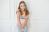 Cute pre-teen girl wearing fashion clothes posing in white