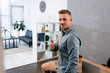 © LIGHTFIELD STUDIOS - cheerful businessman showing thumb up in modern office
