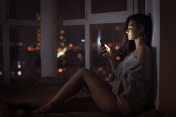 Woman use of mobile phone indoors at night