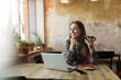 © pikselstock - Young woman with laptop in cafe