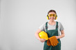 © New Africa - Female industrial worker in uniform on light background, space for text. Safety equipment