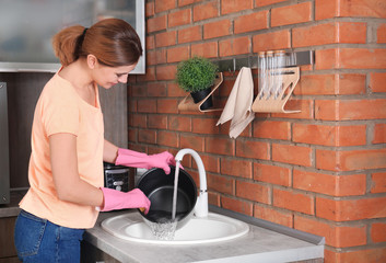 Sticker - Woman washing modern multi cooker in kitchen sink