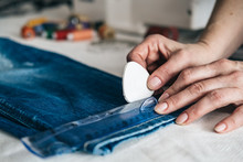 Seamstress Marking Hem On A Pair Of Jeans In Tailor Shop