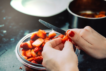 Chef hands slicing fresh strawberries. Bowl with strawberries. Strawberries recipe. Kitchen