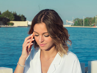 Close up of smiling young girl talking on mobile phone outdoors