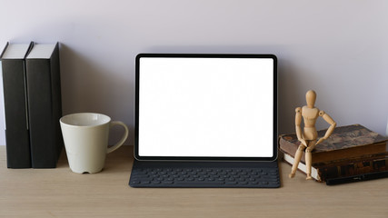 Workspace wooden desk with mockup tablet and smart keyboard