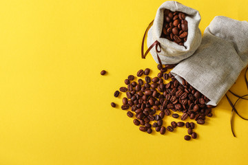 Wall Mural - Bag of coffee beens on yellow background with copy space for your text.