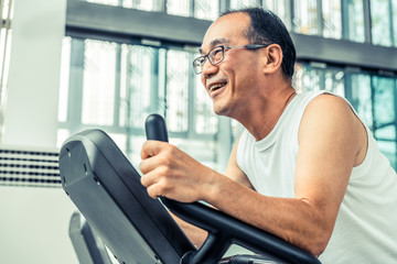 Wall Mural - Senior man exercise on treadmill in fitness center. Mature healthy lifestyle.