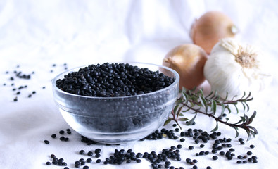 Heap of black organic beluga lentils in a glass bowl on white background.Just like the red lens, it does not need to soak it. Food concept.