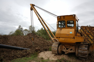 pipelayer tractor puts down pipe or holds pipe