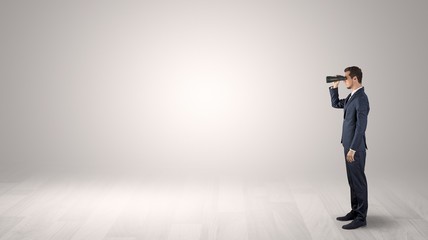 Wall Mural - businessman looking forward with binoculars in an empty space
