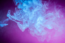 Colorful Blue Smoke  On A Pink Isolated Background. Background From The Smoke Of Vape.