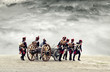 Napoleonic soldiers marching in open plain land with dramatic clouds., pulling a cannon.