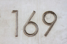 A Dirty Number 169 Engraved Into White Stone. One Hundred Sixty Nine Carefully Engraved