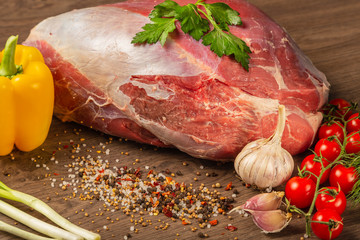 Wall Mural - Raw beef on a wooden background with spices and vegetables.