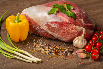 Wall Mural - Raw beef on a wooden background with spices and vegetables.