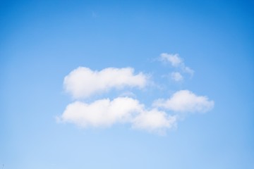 Wall Mural - Fluffy white clouds on the clear blue sky background.