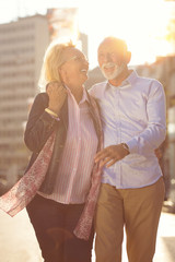 Wall Mural - Happy nice mature couple walking in town