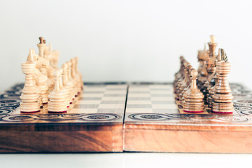 Wooden chess pieces on a chessboard, leadership concept on white background.