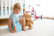 Cute toddler boy, potty training, playing with his teddy bear