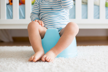 Cute toddler boy, potty training, playing with his teddy bear