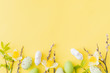 Flat lay easter composition with yellow daffodils and eggs on a yellow background