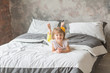 Happy child girl having fun on a bed