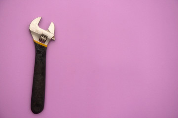 Adjustable wrench on pink background with copy space 