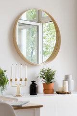 Round mirror hanging over cabinet