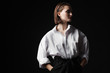 Portrait of an elegant young woman in a white shirt and black pants. Interesting studio light