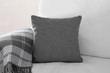 © Sarah - Mockup of a grey square cushion on a white sofa next to a grey plaid blanket.