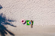 © naproadavida_npv - Aerial view of a young woman with a brazilian flag on the beach. Crystal clear water, tropical vacation scenario, coconut tree and boats. Drone view