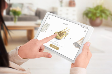 Wall Mural - Girl add shoes to the shopping cart with online app. Concept of online store.