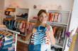 © Westend61 - Smiling pregnant woman shopping for baby clothing in a boutique