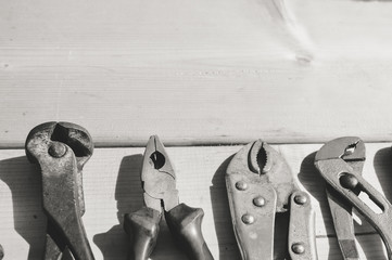 Tool set and instruments for hand work and fixing on wooden surface background. Close up top side view mockup design production details Black and white photography image.