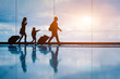 Leinwandbild Motiv Family at airport travelling with young child and luggage walking to departure gate, girl pointing at airplanes through window, silhouette of people, abstract international air travel concept