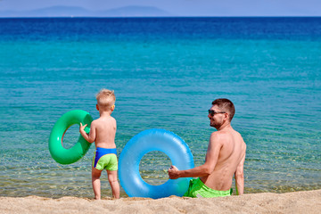 Toddler boy on beach with father