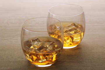 Two glasses with whiskey with ice cubes	